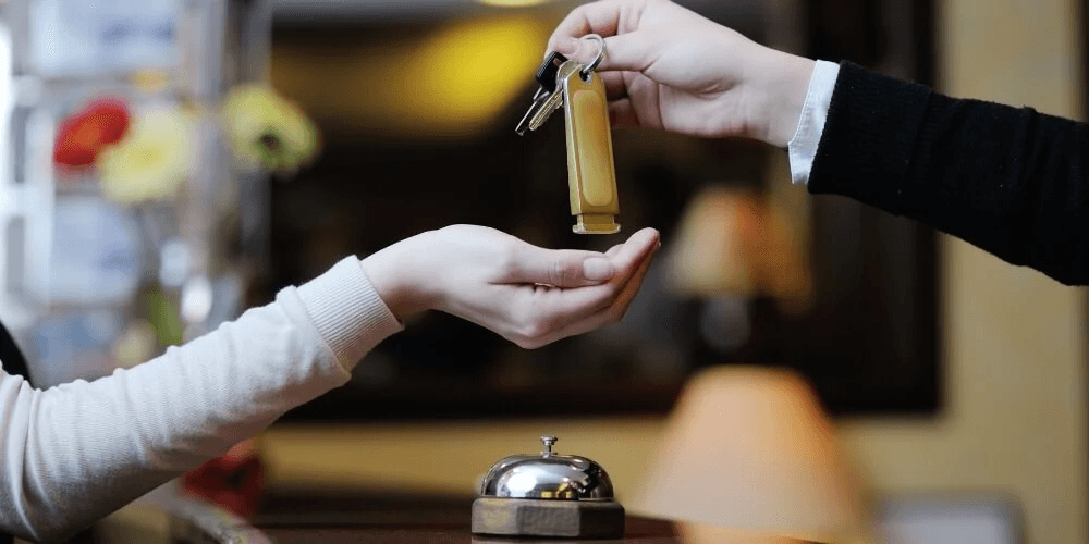 hotel staff handing a key to a guest